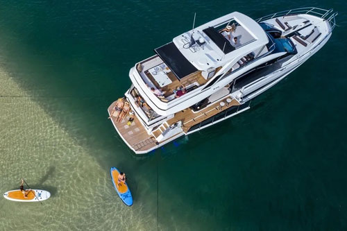 Motor Yacht Starting Over anchored with guests using paddle boards
