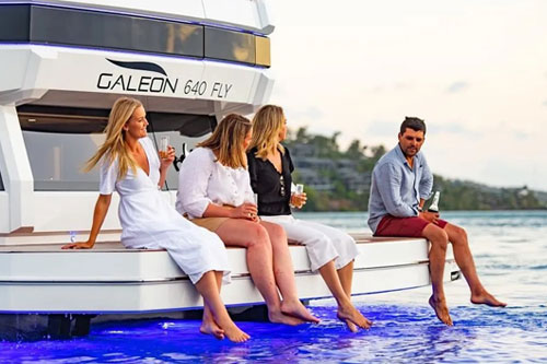 Motor Yacht Starting Over swim platform with guests seated enjoying sundowners